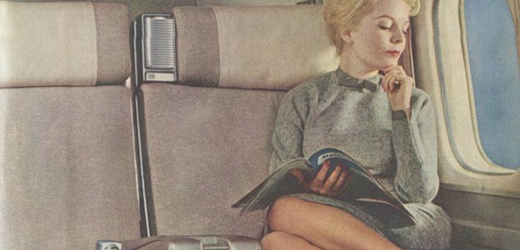 a woman sitting on a plane reading a book