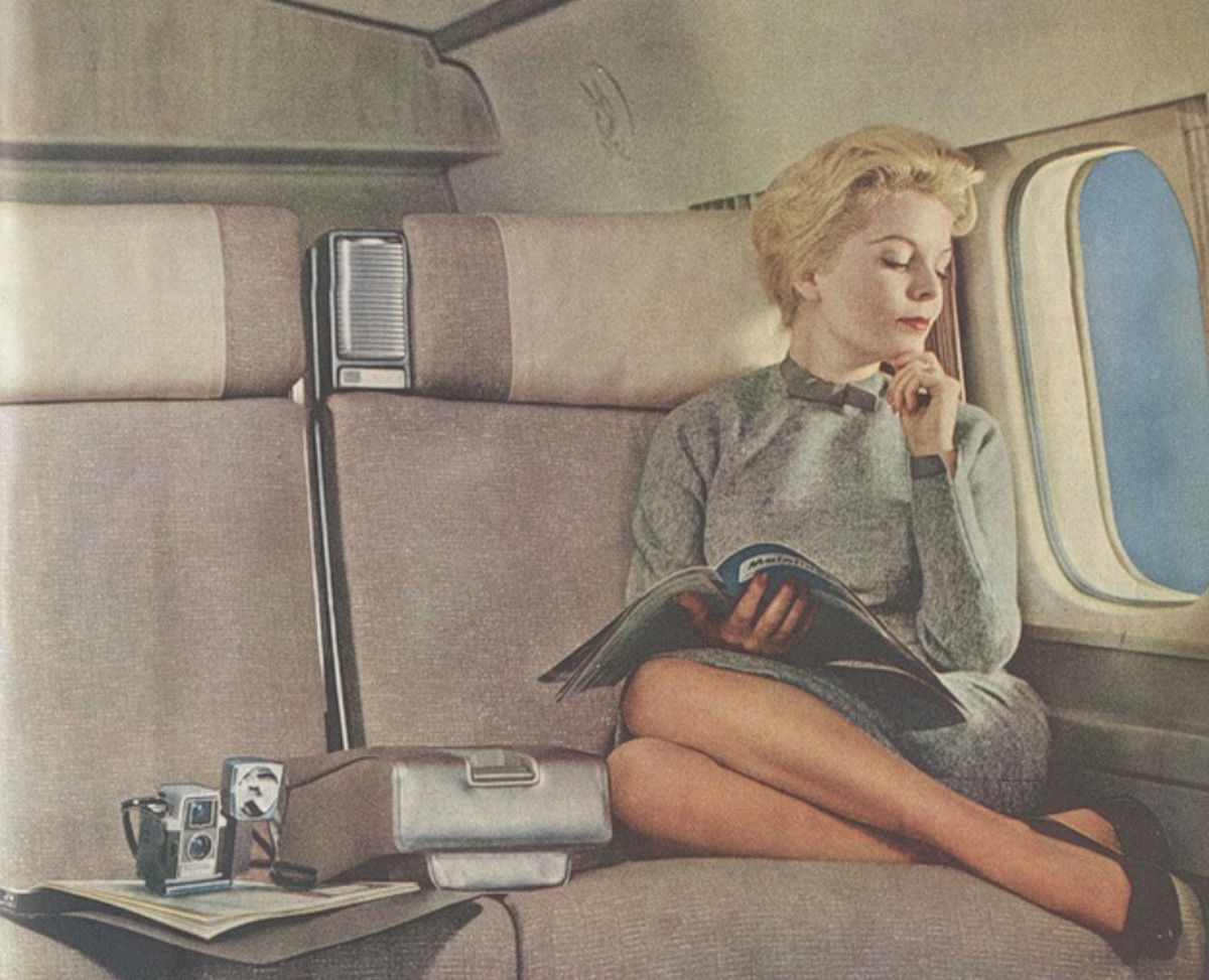 a woman sitting on a plane reading a book