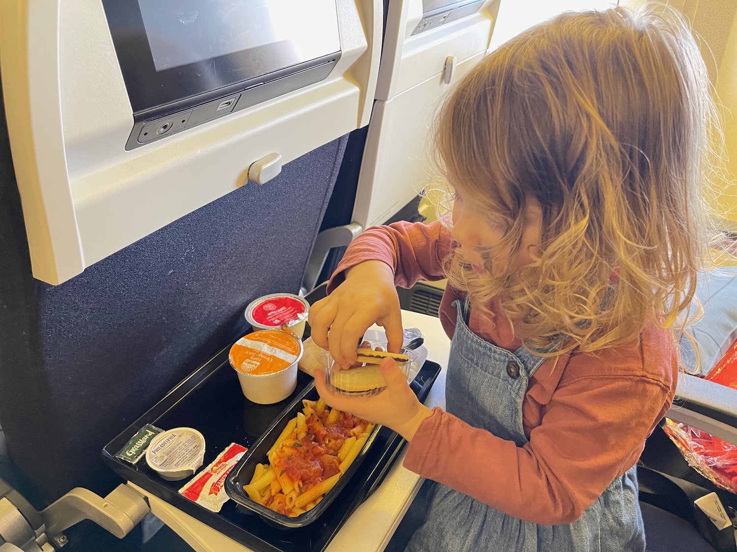 a girl eating food on a tray