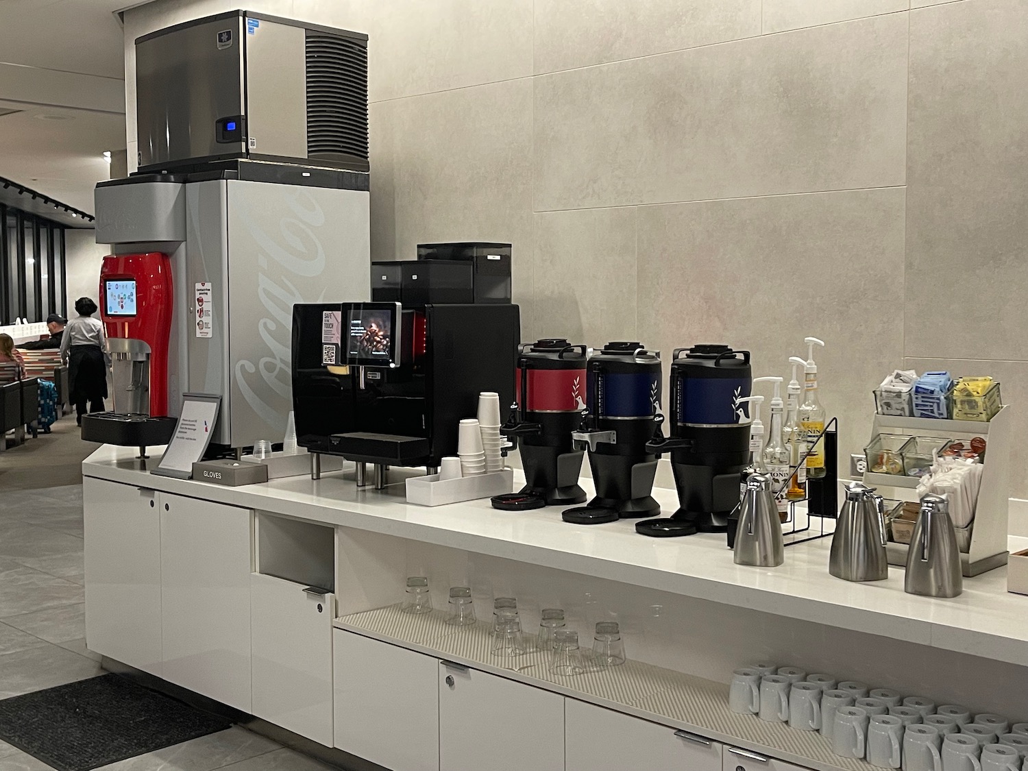 a counter with coffee machines and cups