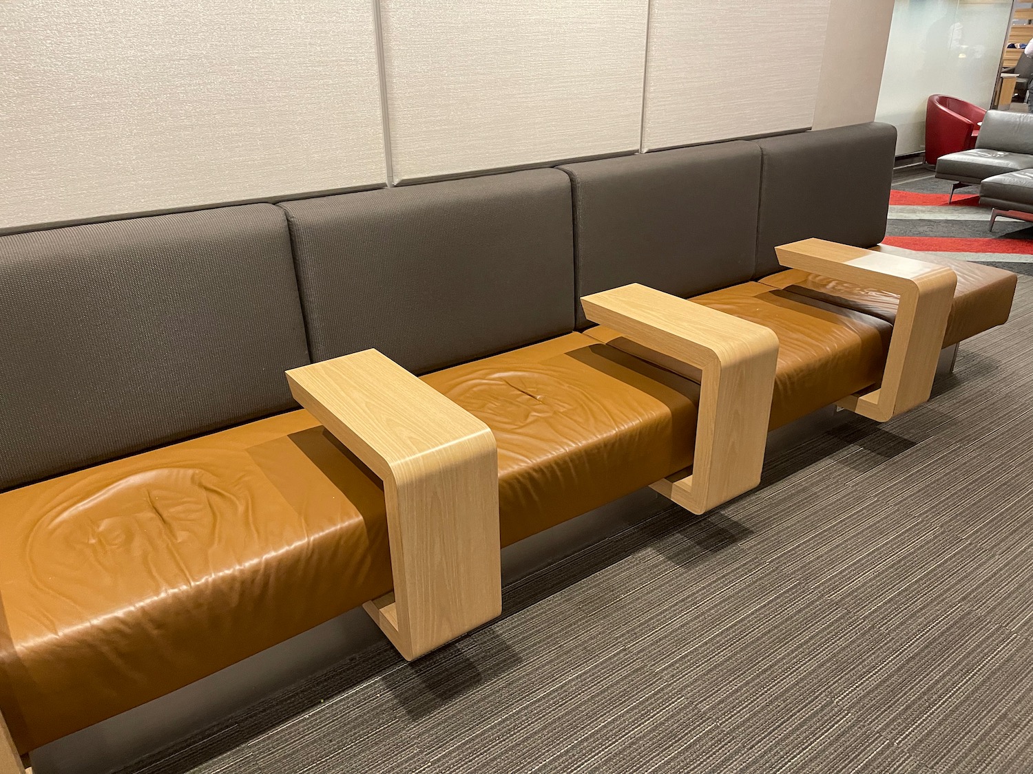 a brown bench with wooden armrests