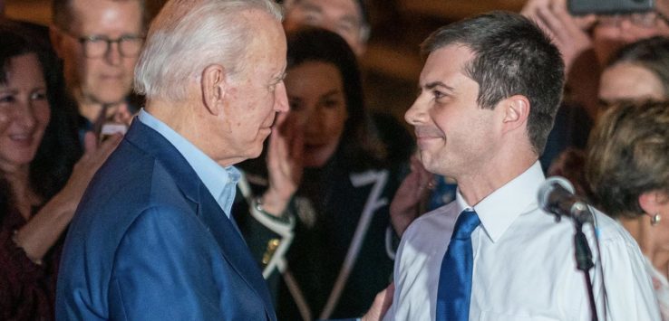 a man in a suit and tie shaking hands with another man in a crowd