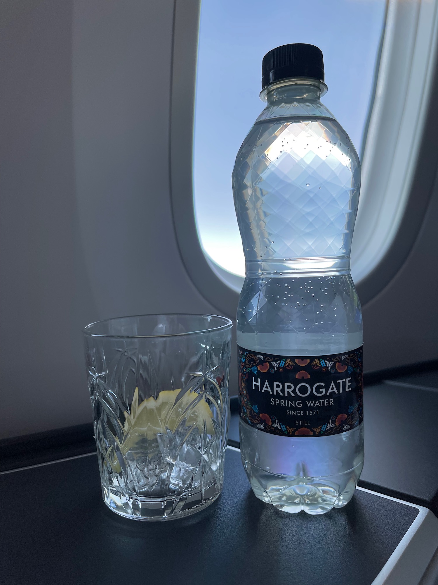 a bottle of water and a glass on a plane