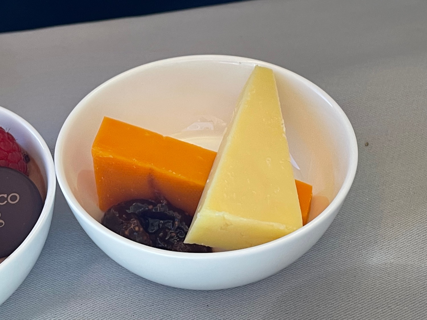 a bowl of cheese and raisins