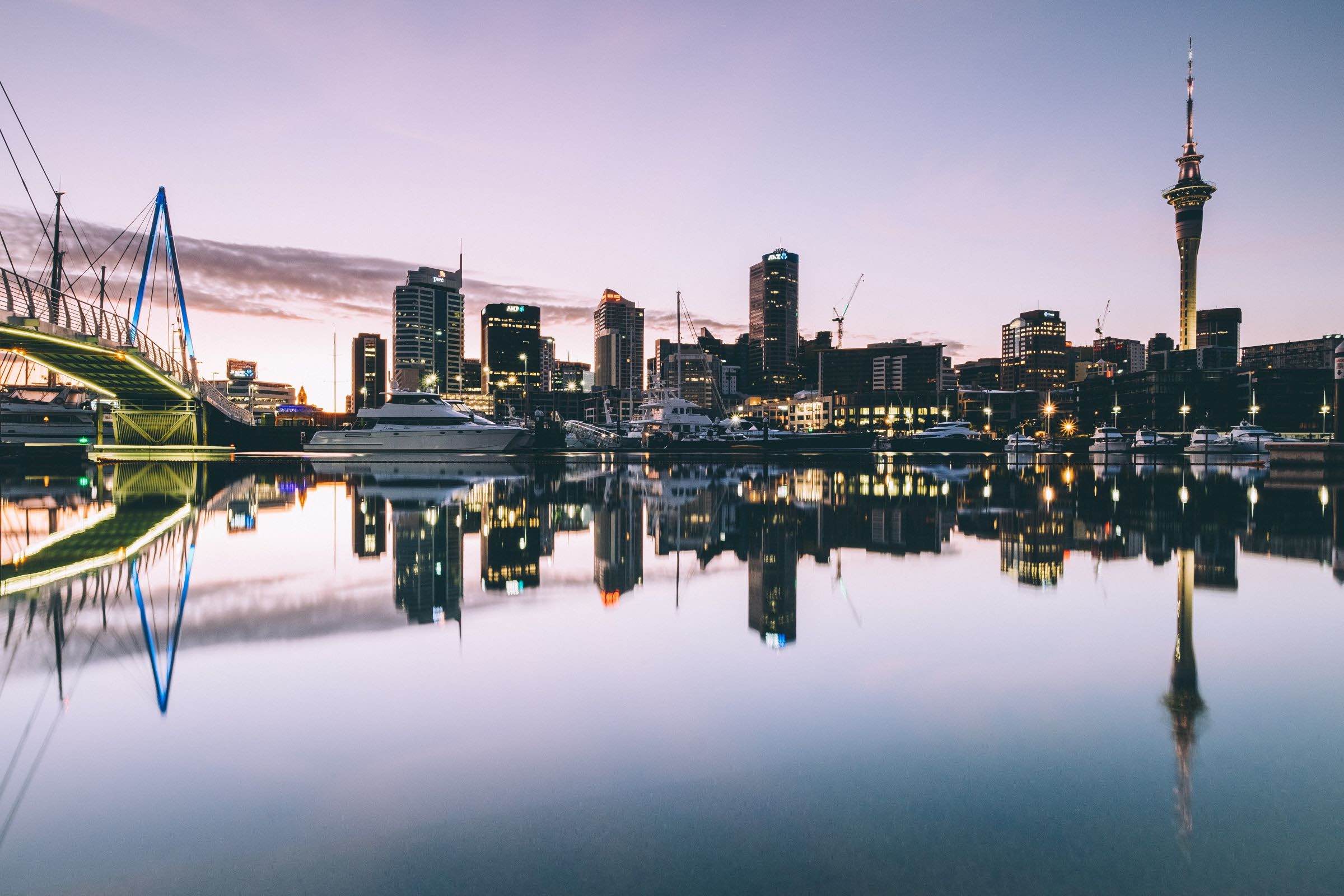 a city skyline with boats and buildings reflected in water