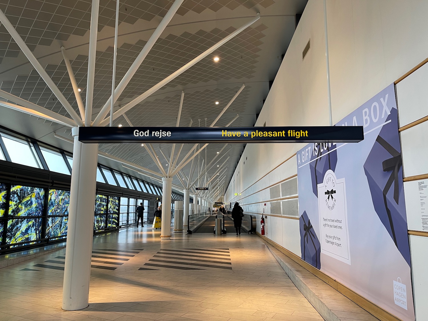 a long walkway with a sign and people walking