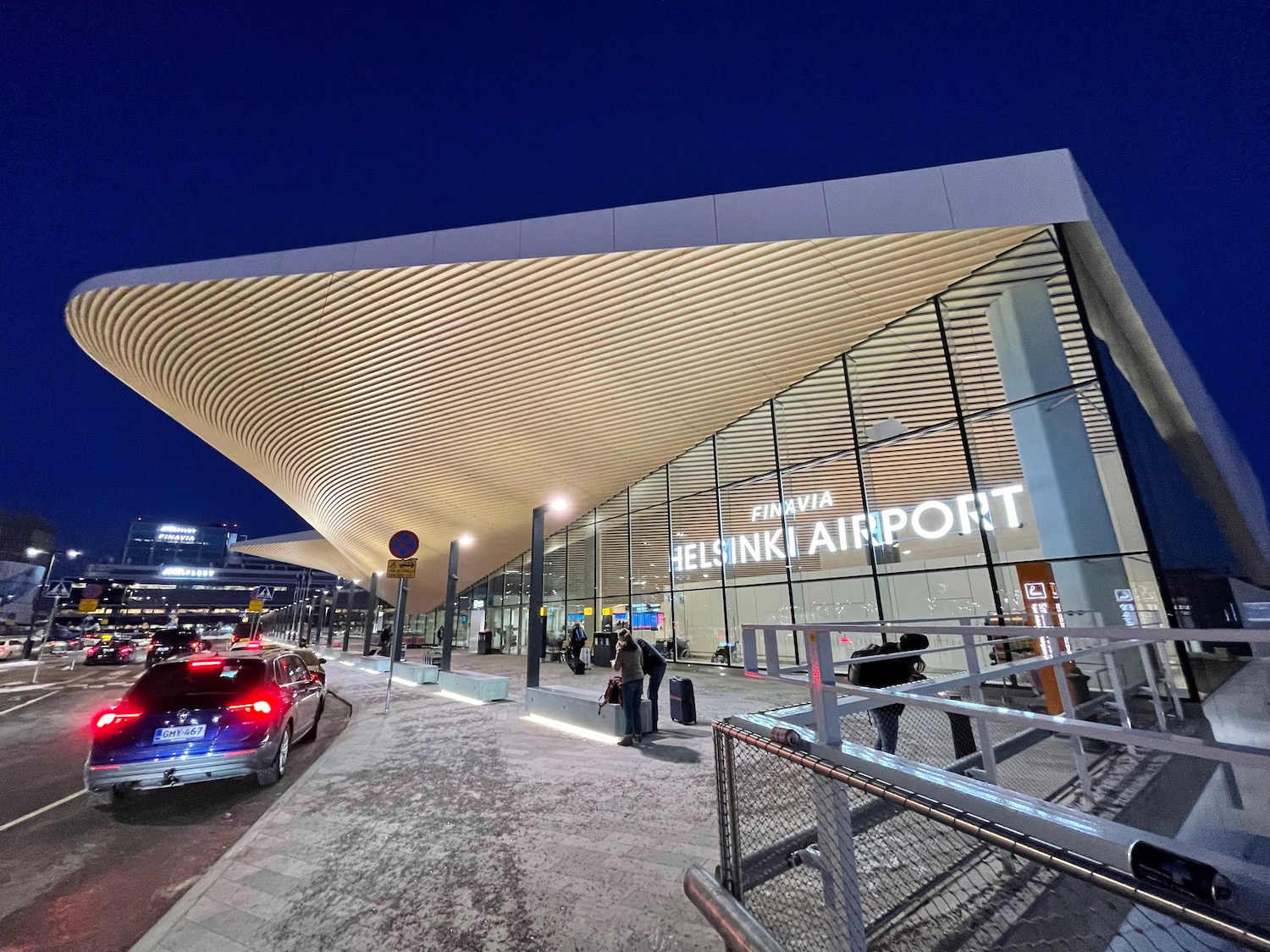 a building with a triangular roof and cars parked outside