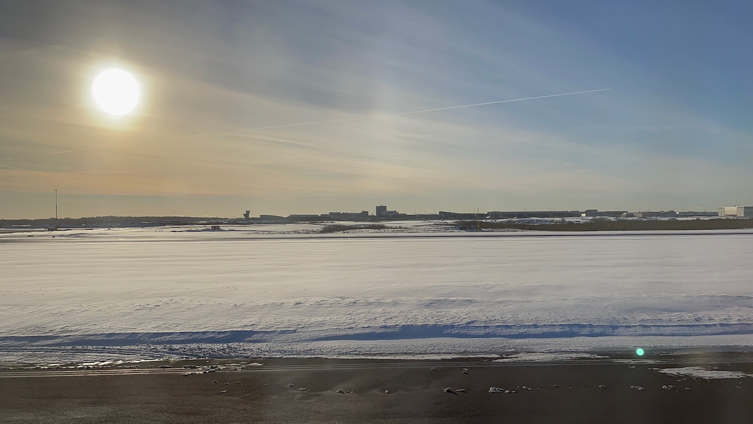 a snow covered ground with buildings in the background