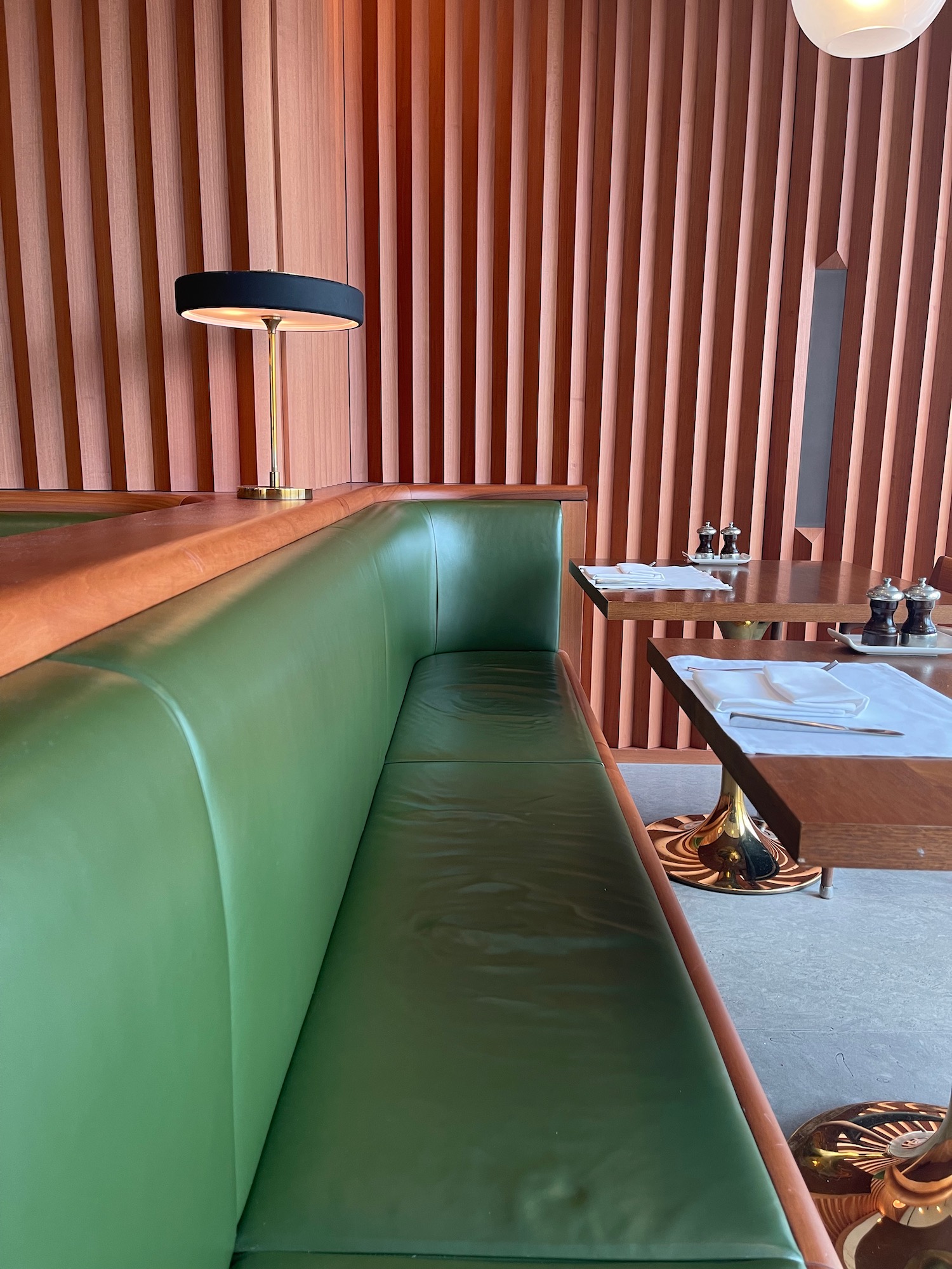 a green booth with a lamp and table in a restaurant