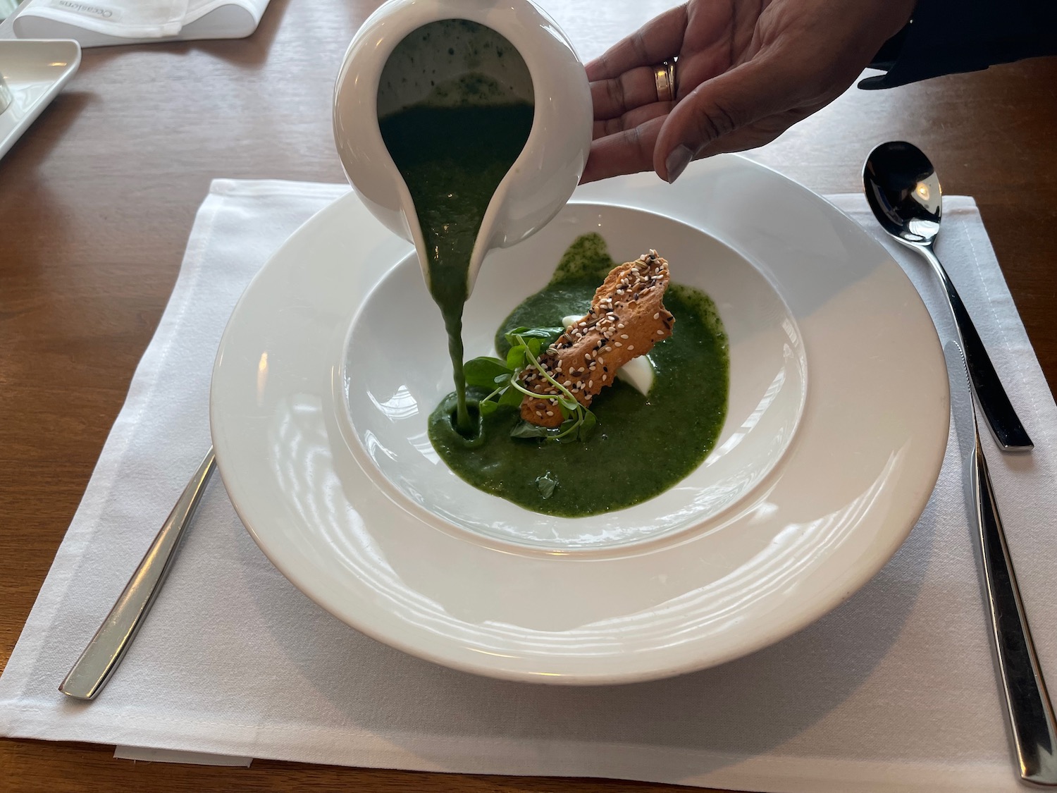 a person pouring a sauce into a bowl of food