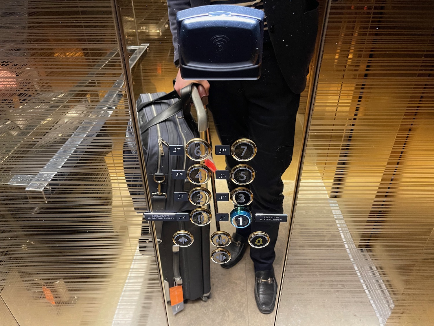 a person holding a luggage bag in an elevator