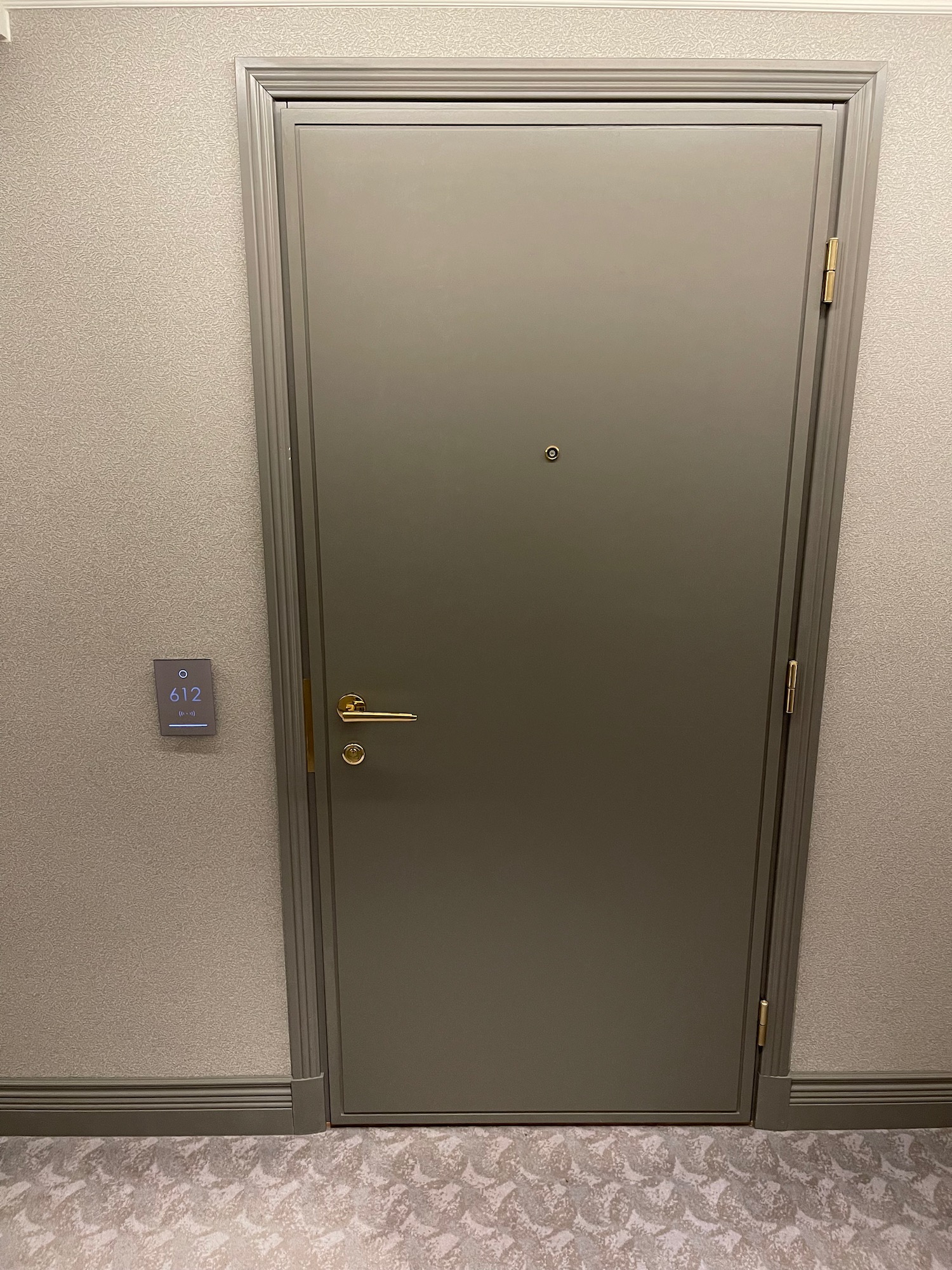 a grey door with a gold handle