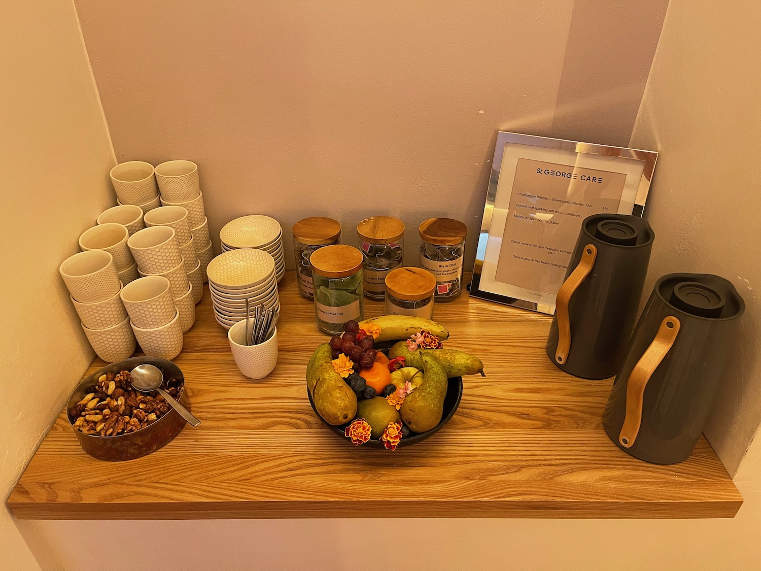 a bowl of fruit and cups on a table