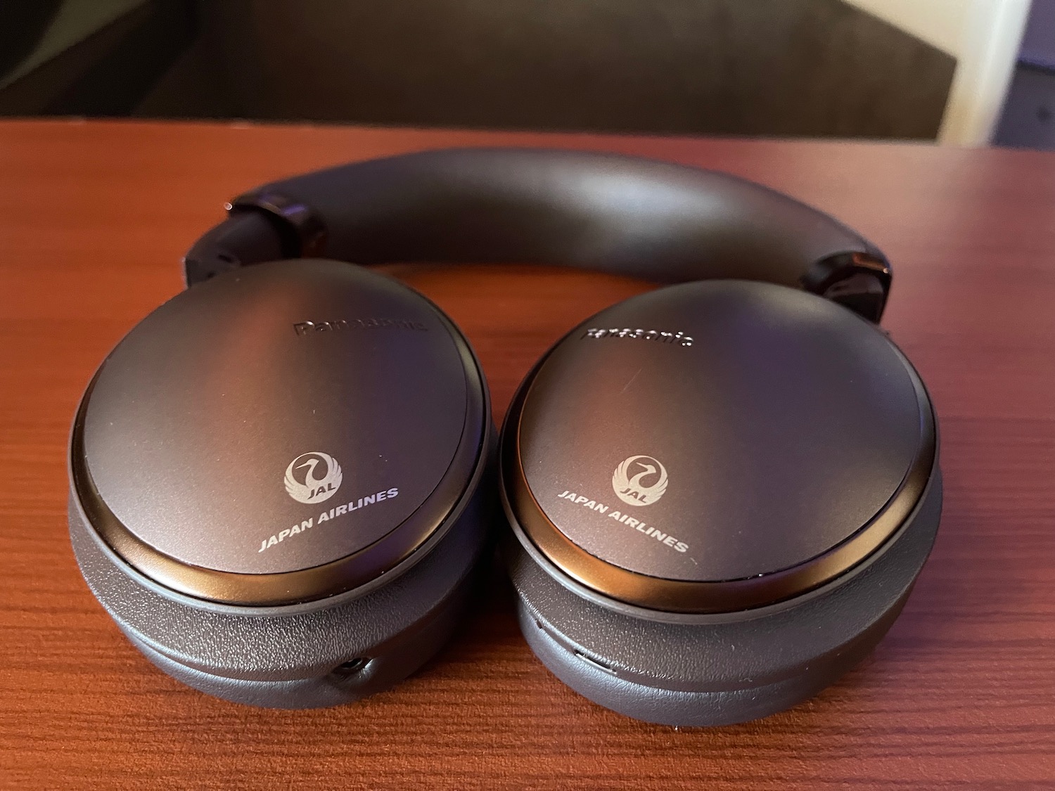 a pair of black headphones on a wood surface