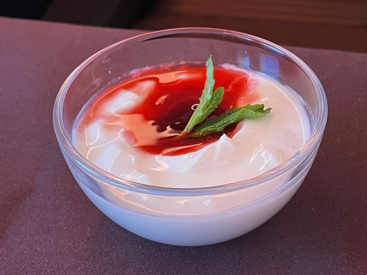 a bowl of yogurt with a green leafy topping
