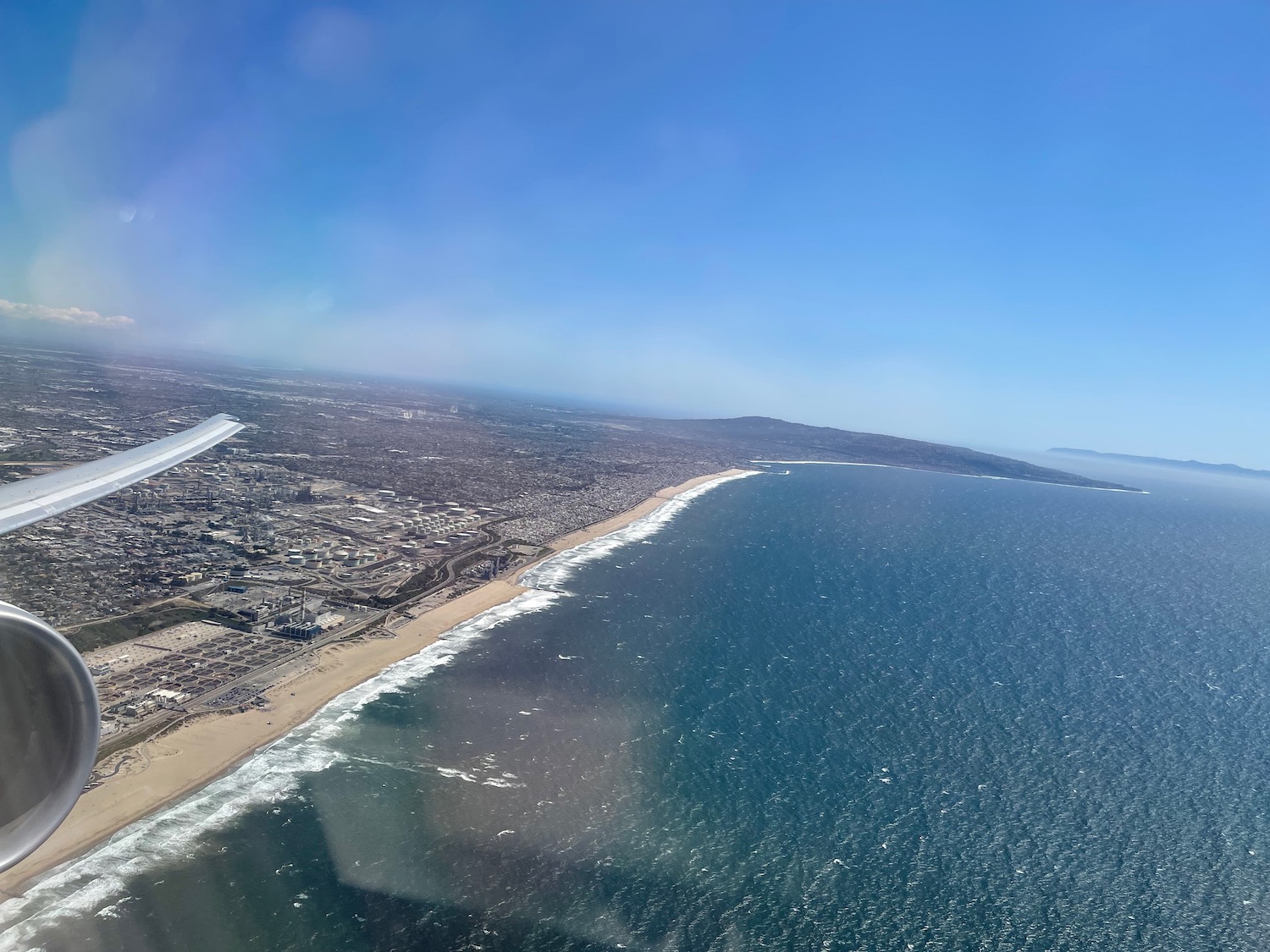 a beach and ocean with buildings and blue sky