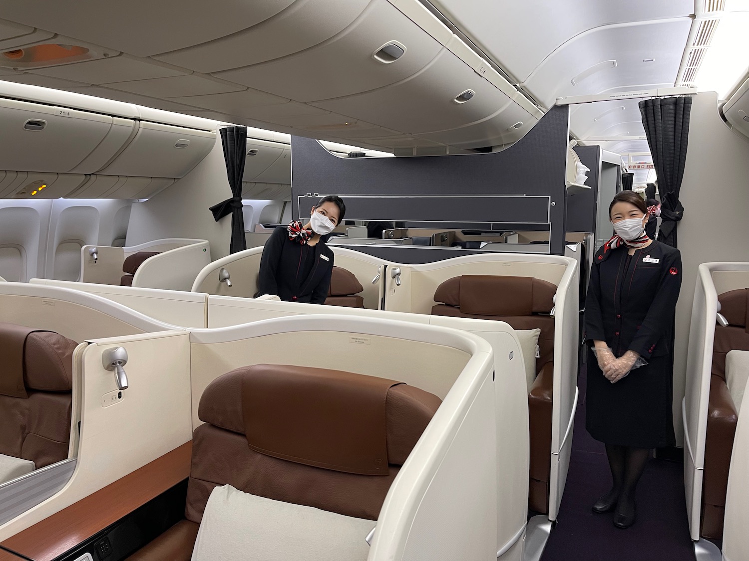 two women wearing face masks in an airplane