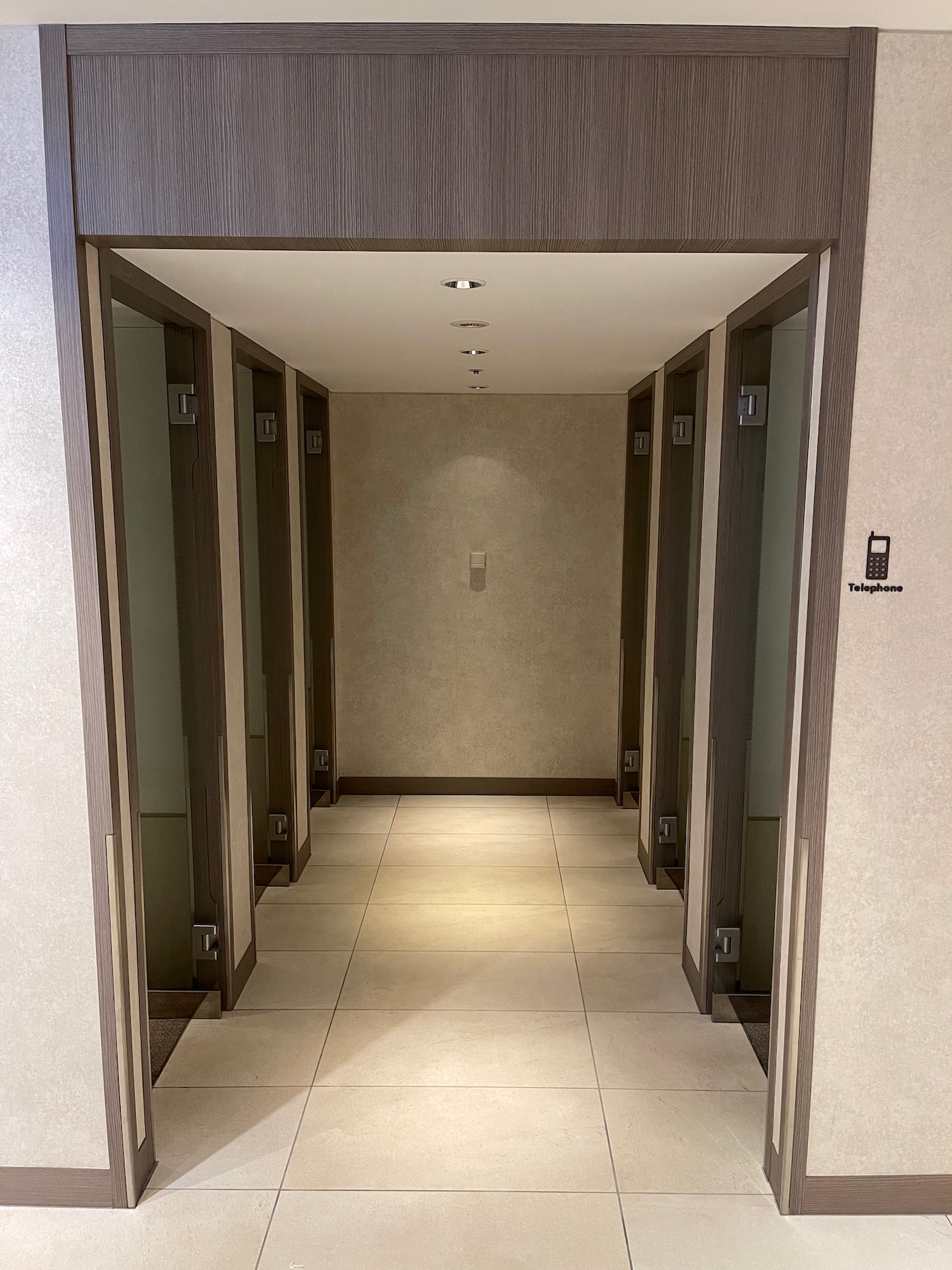 a hallway with doors and a phone on the wall