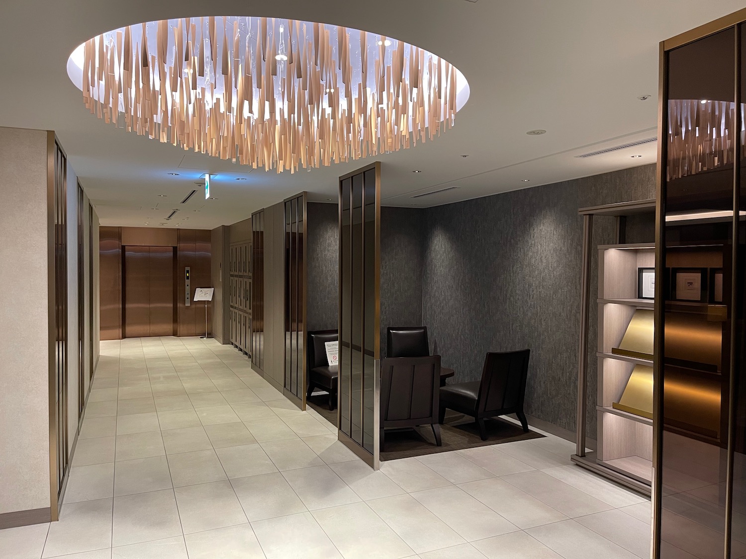 a hallway with chairs and a chandelier