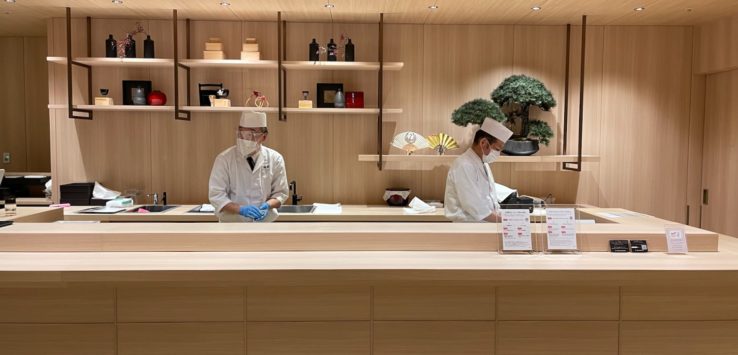 a group of people in white coats and masks standing in front of a counter