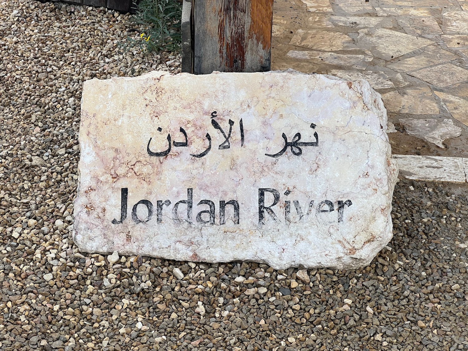 a stone sign on gravel