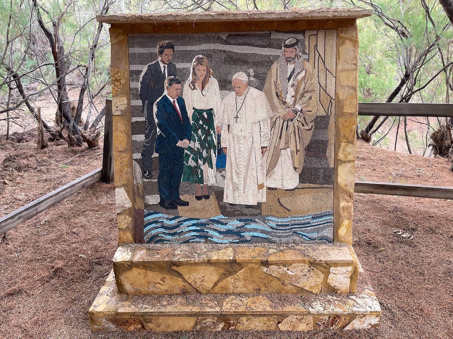 a mosaic of people on a stone pedestal