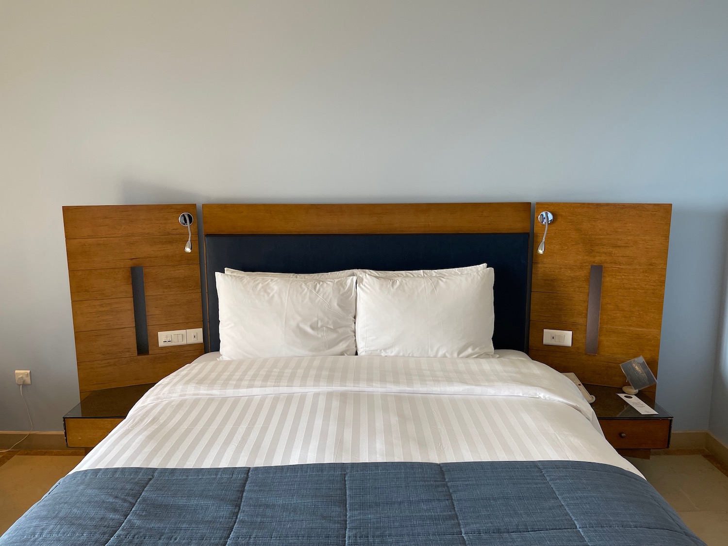 a bed with a blue blanket and a blue headboard