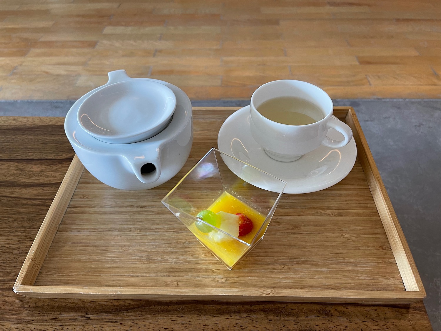 a tray with tea cups and a small square container with jelly