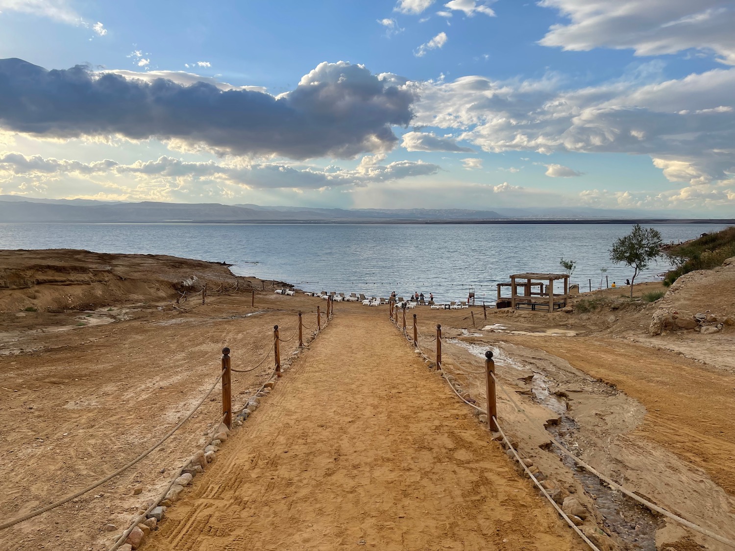 a dirt path leading to a body of water