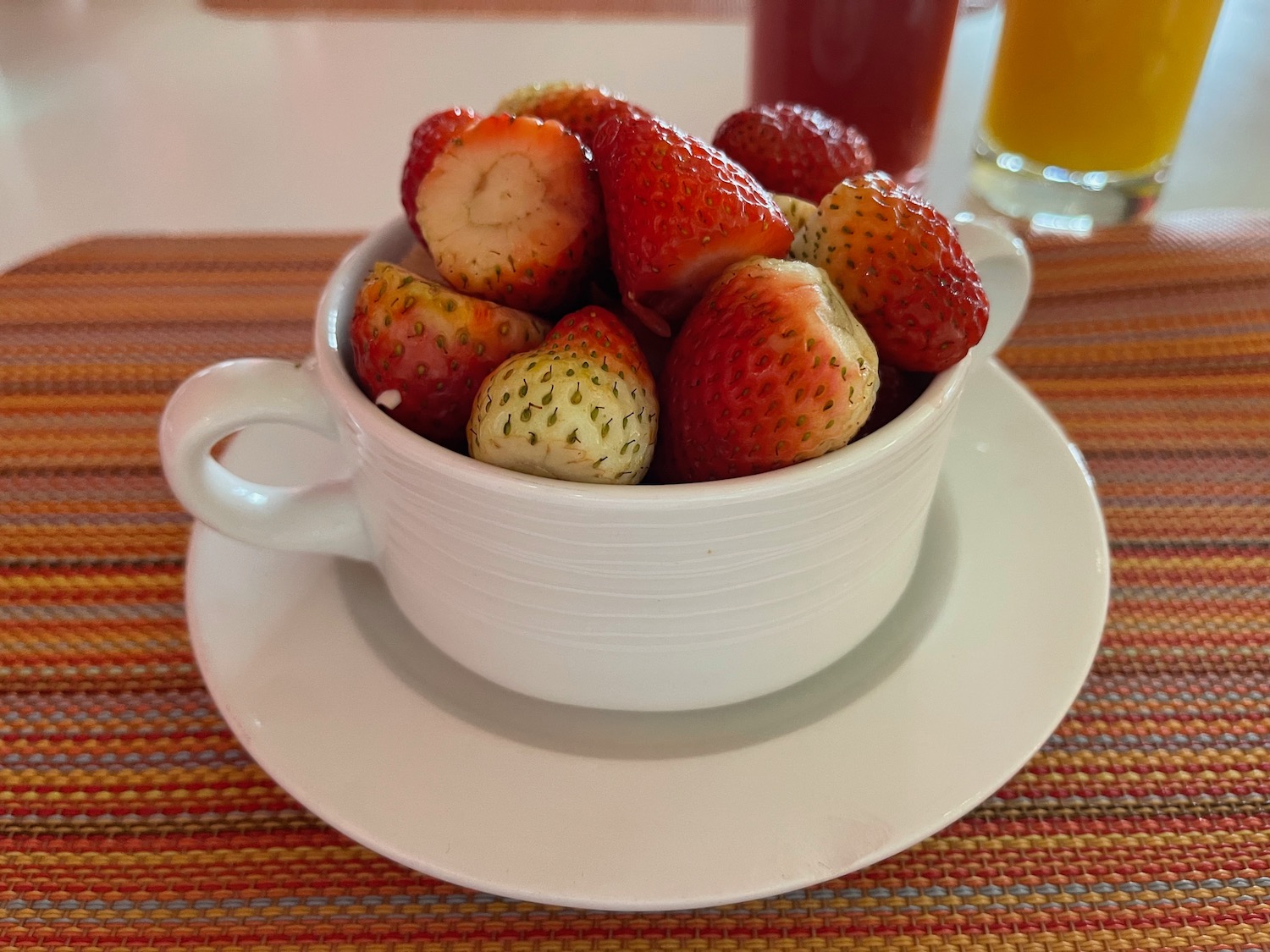 a cup of strawberries on a plate