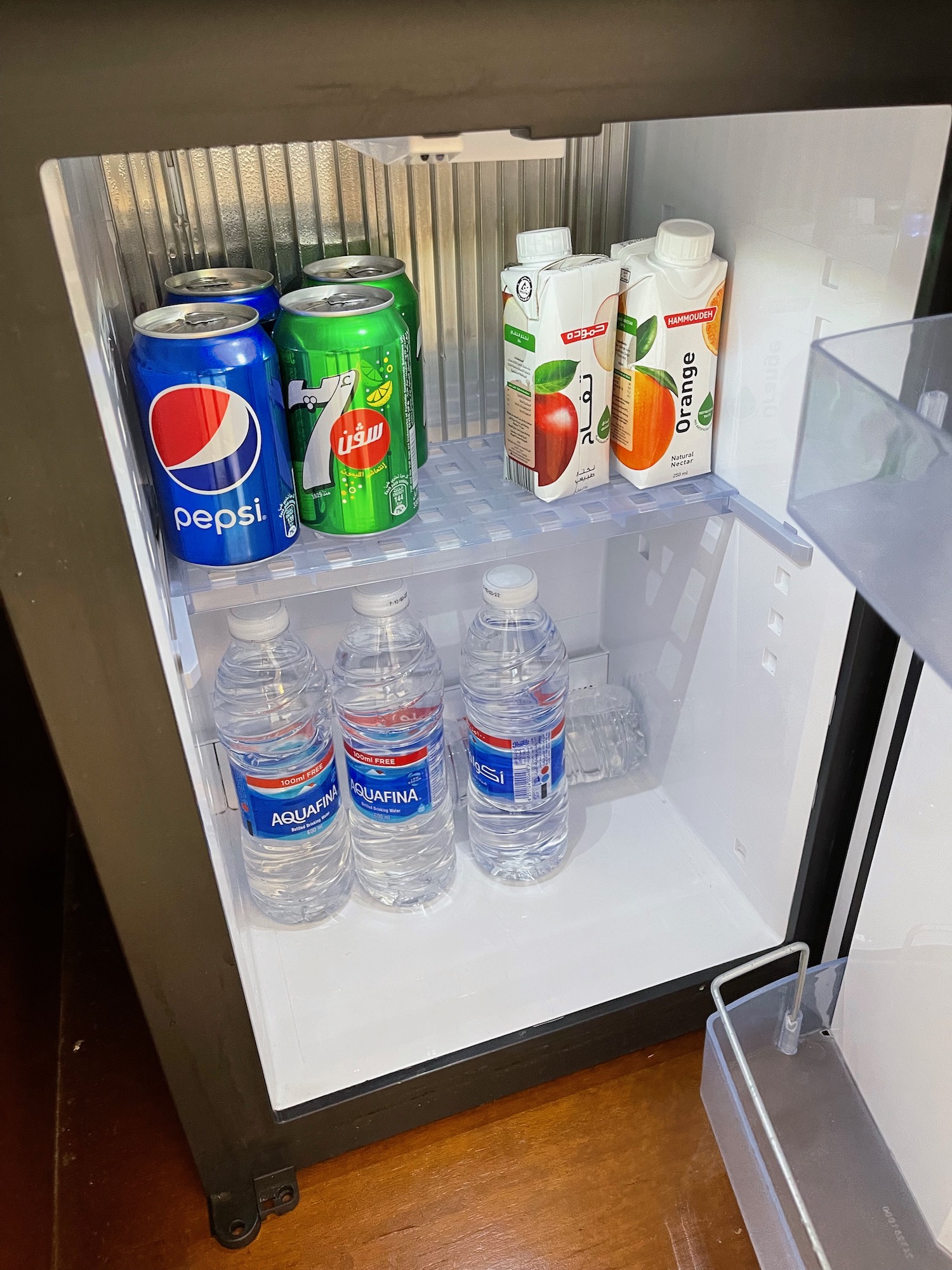 a refrigerator with cans of soda and water