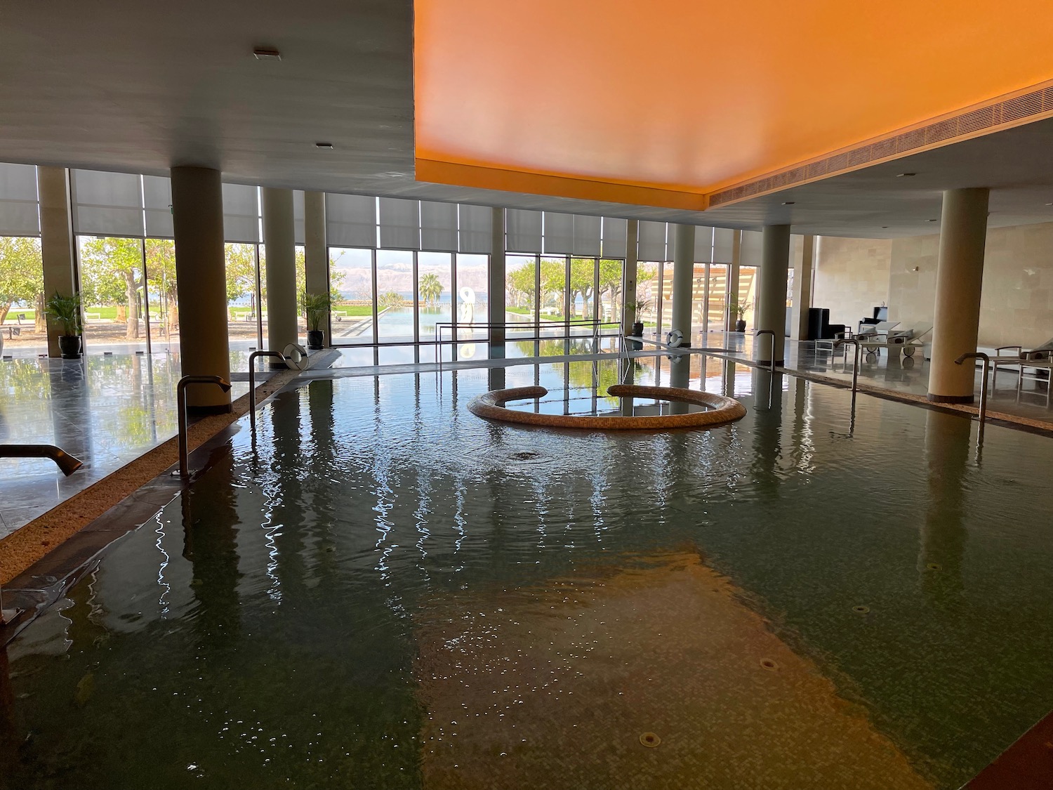 a large indoor pool with a large tub and a large window