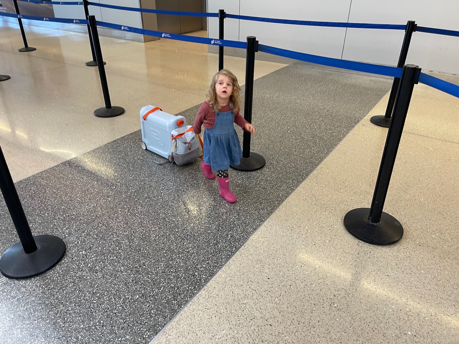 a girl walking with luggage in an airport