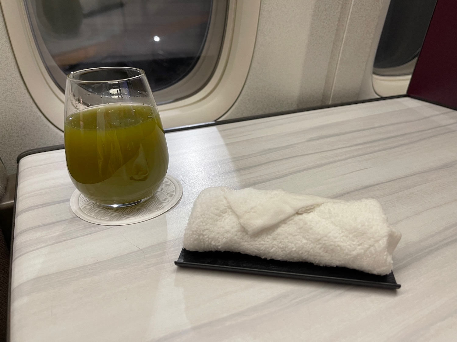 a glass of juice and a towel on a table