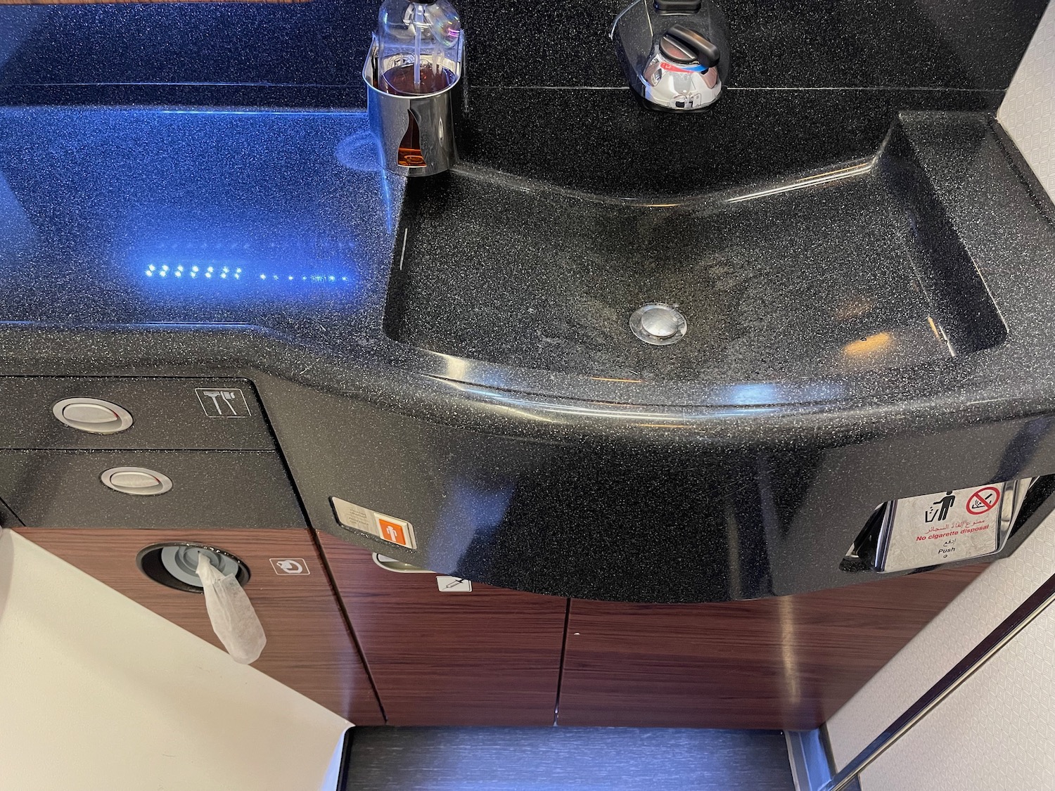 a black sink with a soap dispenser and a black counter top