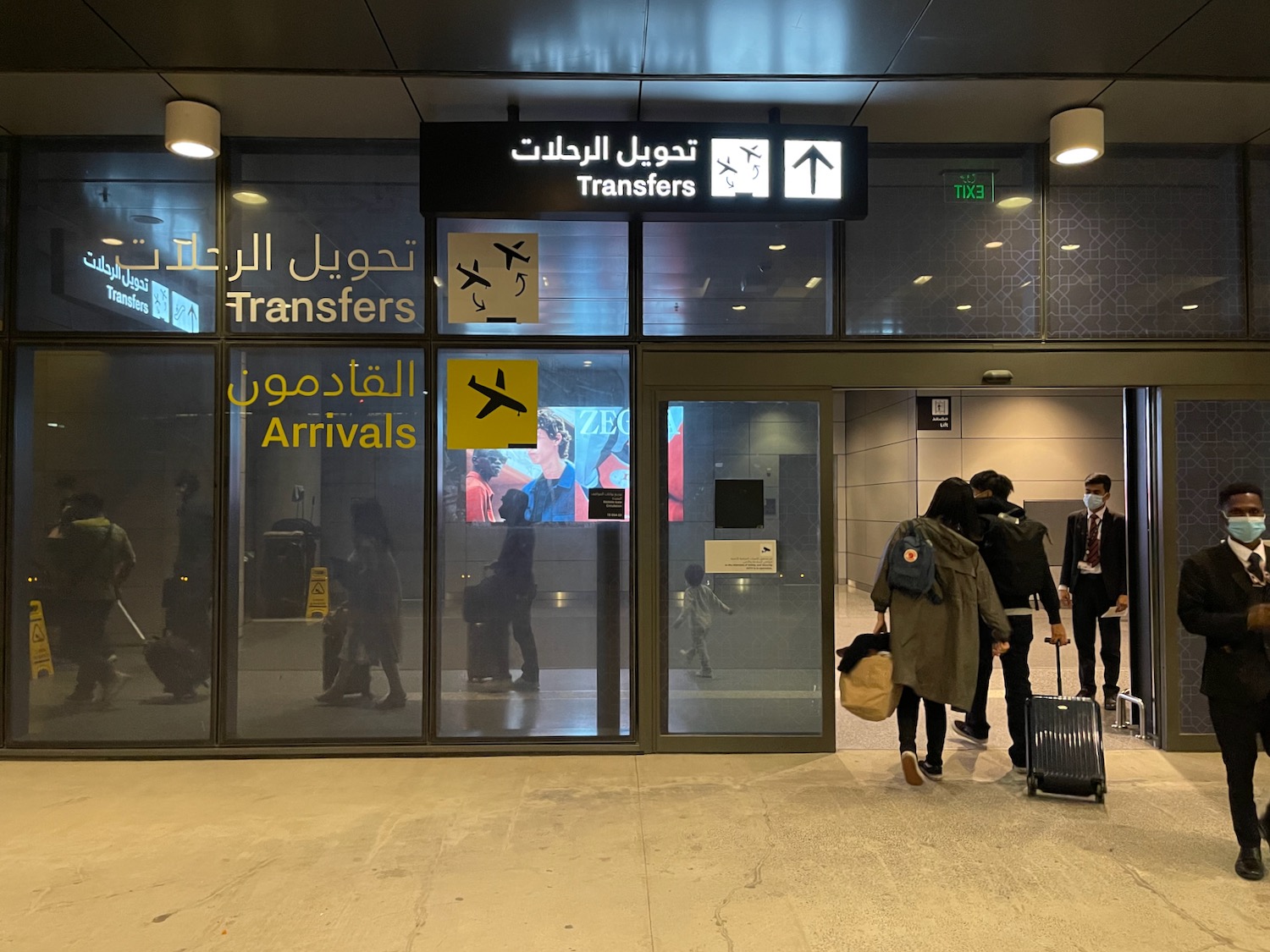 people walking in a building with luggage