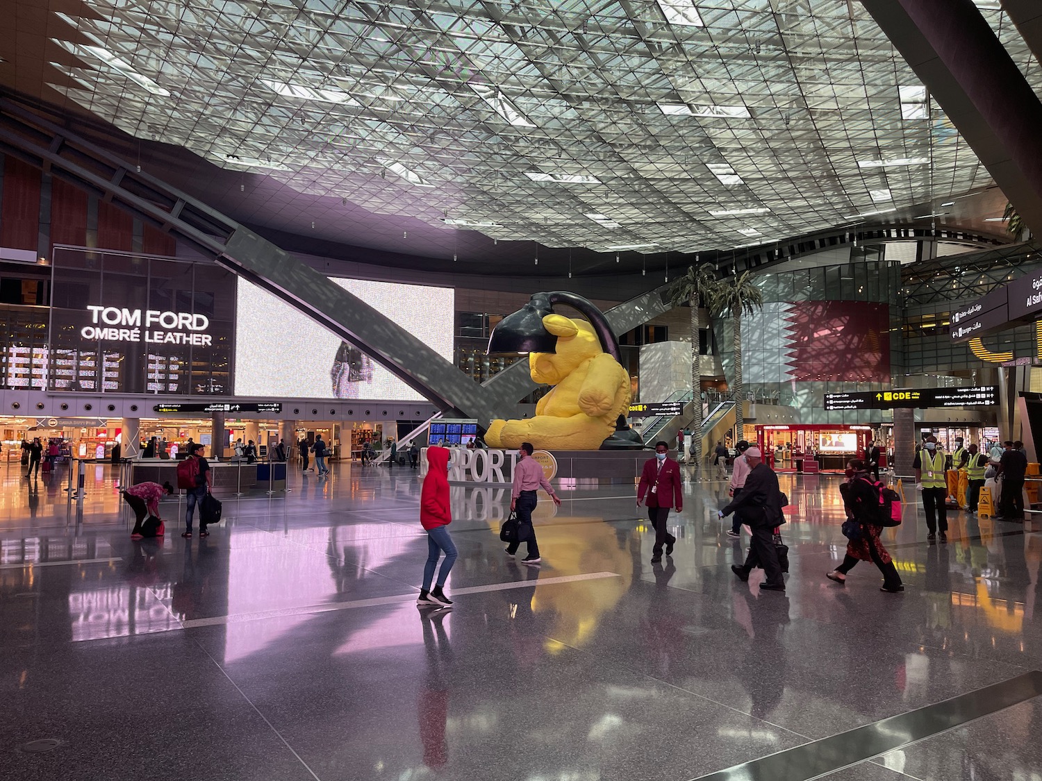 a large yellow bear statue in a large airport