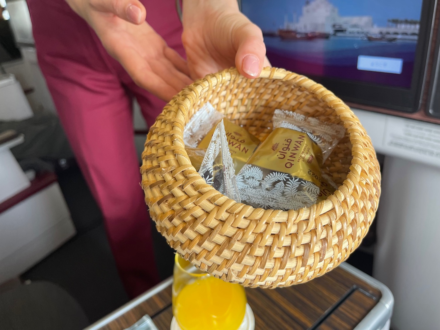 a hand holding a basket with food in it