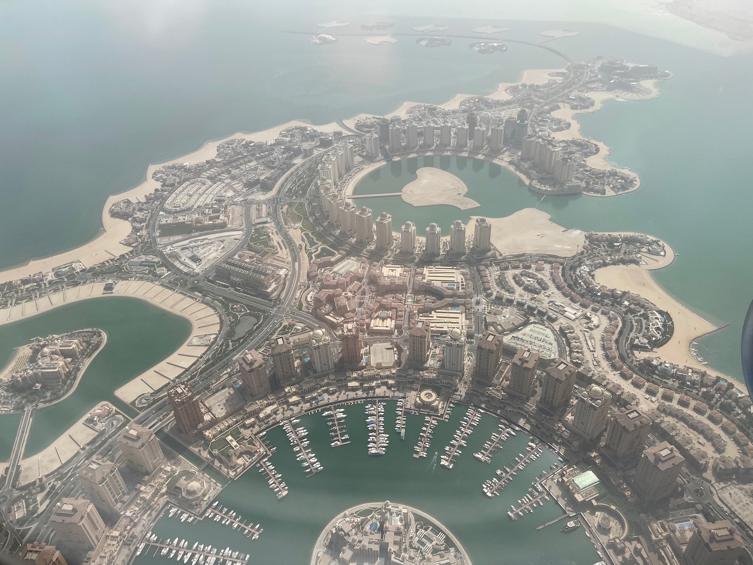 an aerial view of a city with many boats in the water