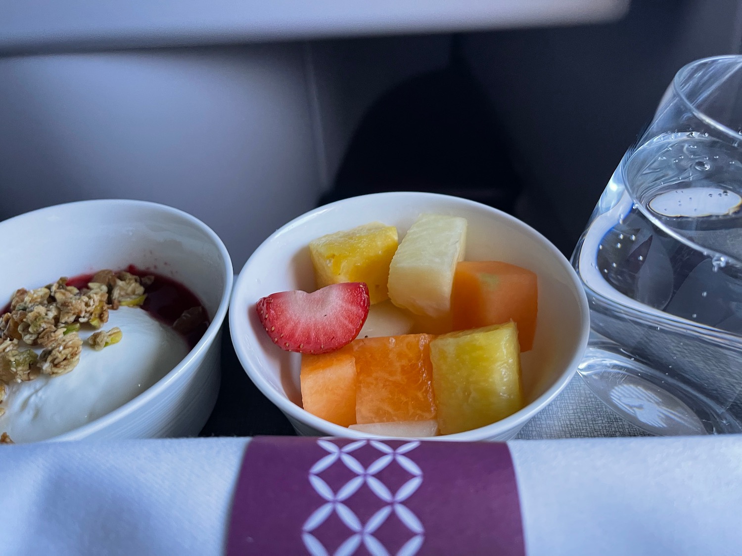 a bowl of fruit and yogurt on a tray