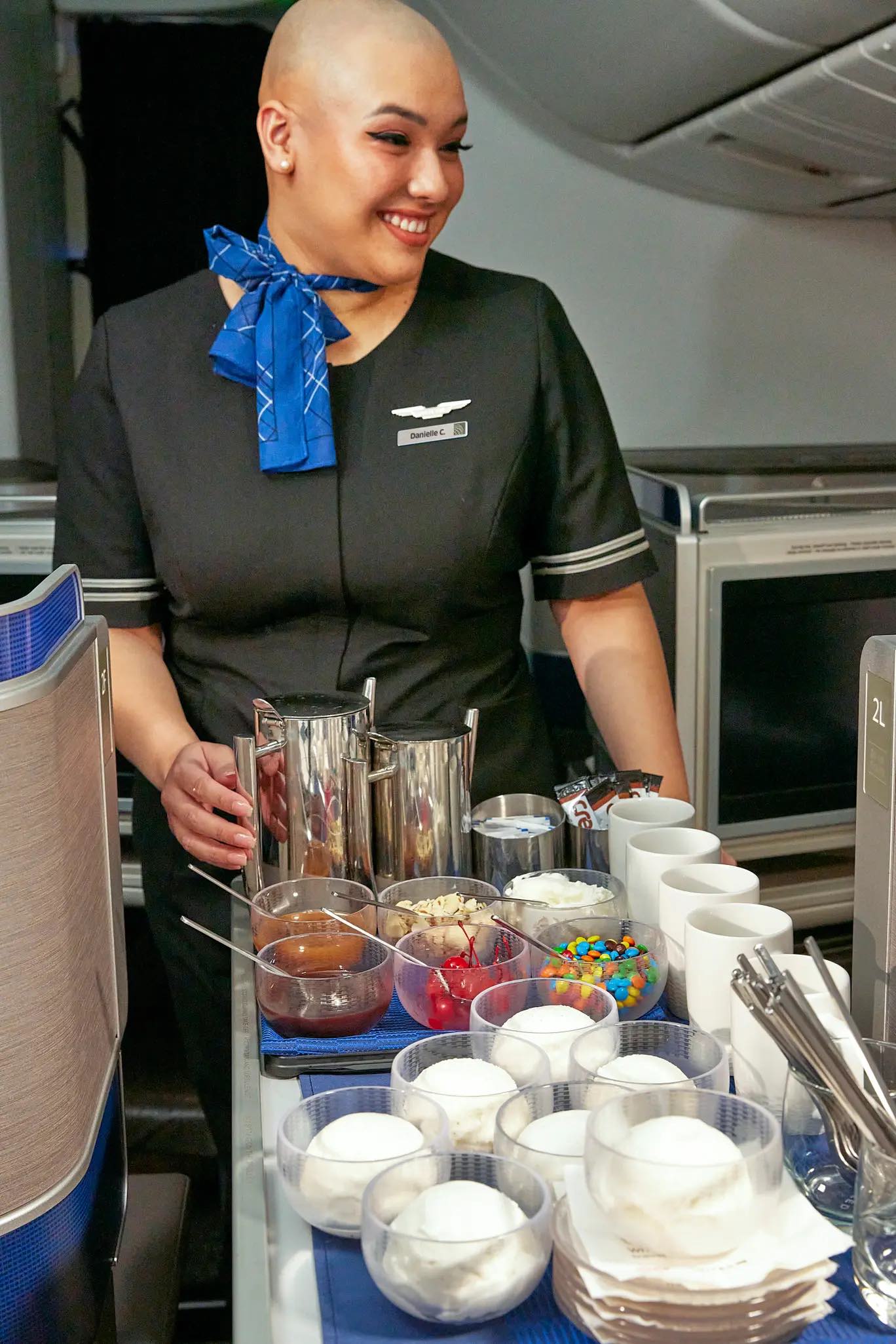 a woman in uniform standing behind a table with food