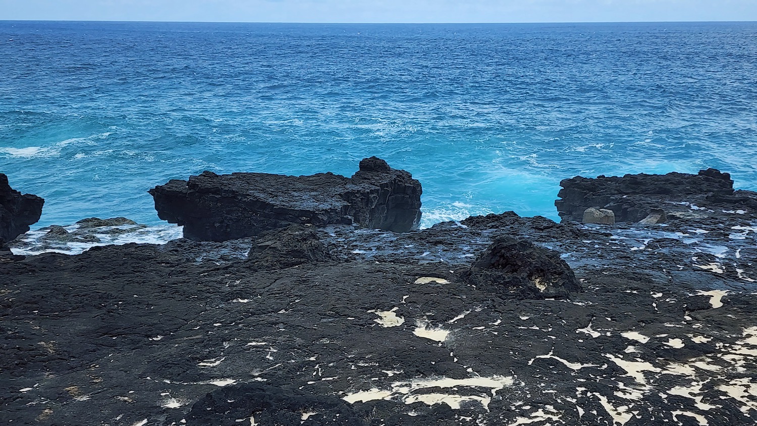 a rocky shore with blue water