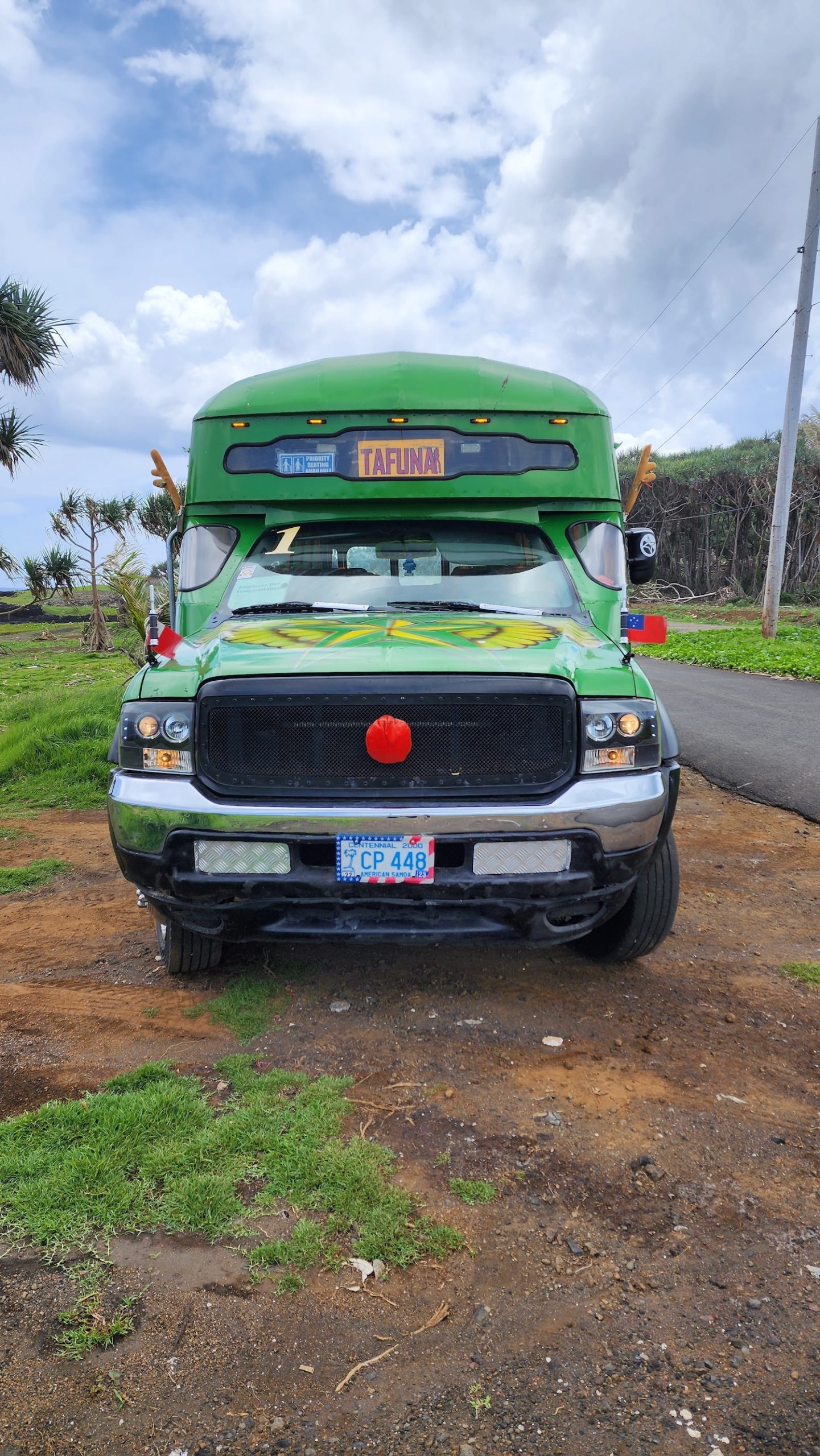 a green truck parked on a dirt road