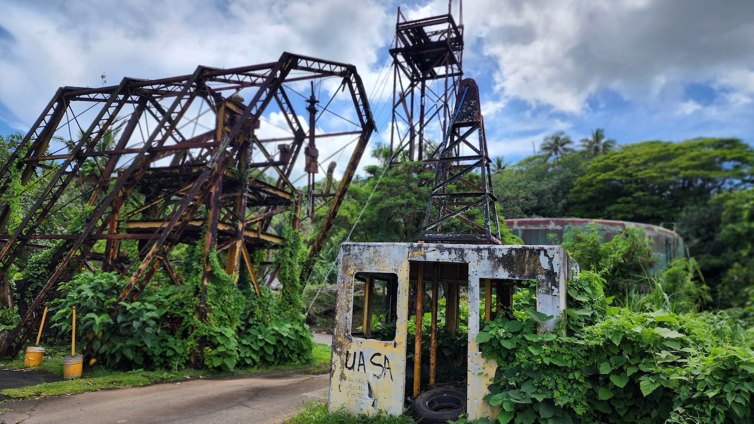 a rusty metal structure with plants around it