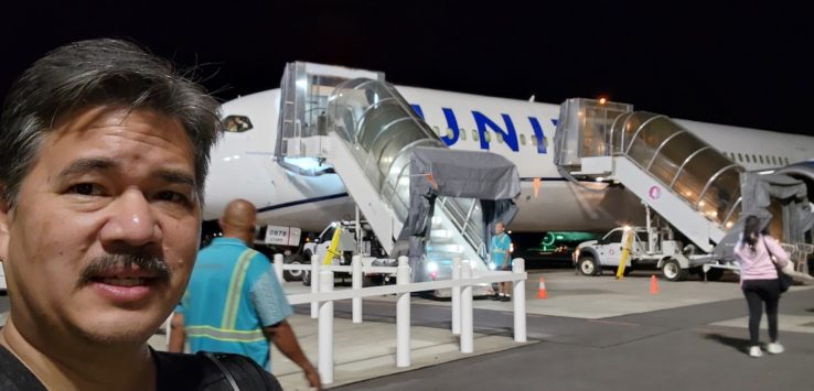 a man walking down a walkway to an airplane