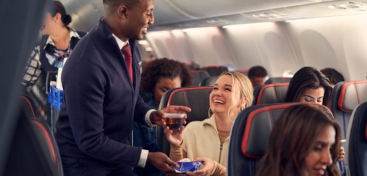 a man giving a drink to a woman on an airplane