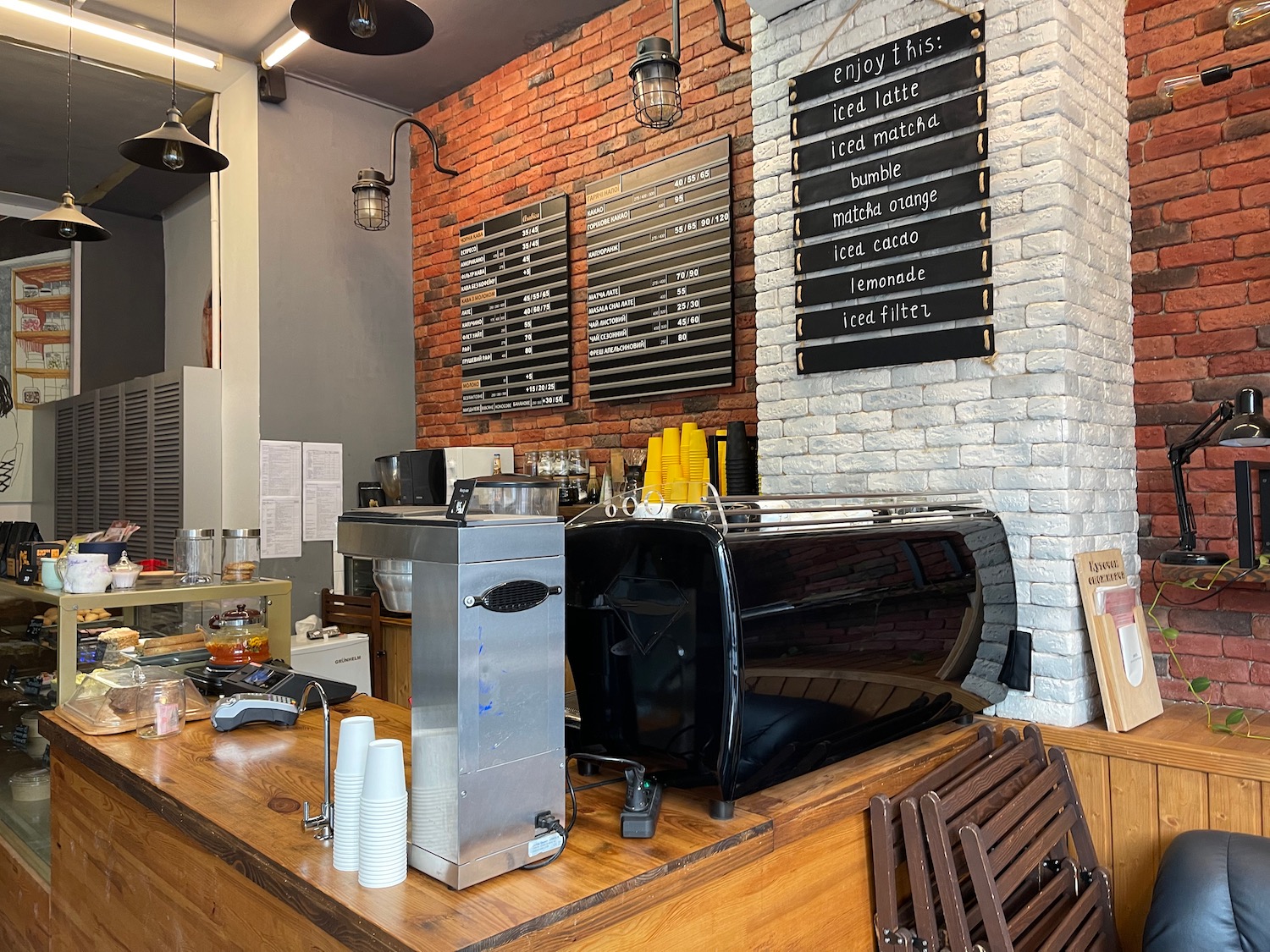 a coffee shop with a black coffee machine and a black sign on the wall