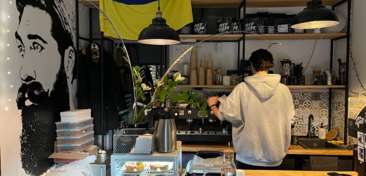 a person standing behind a counter in a coffee shop