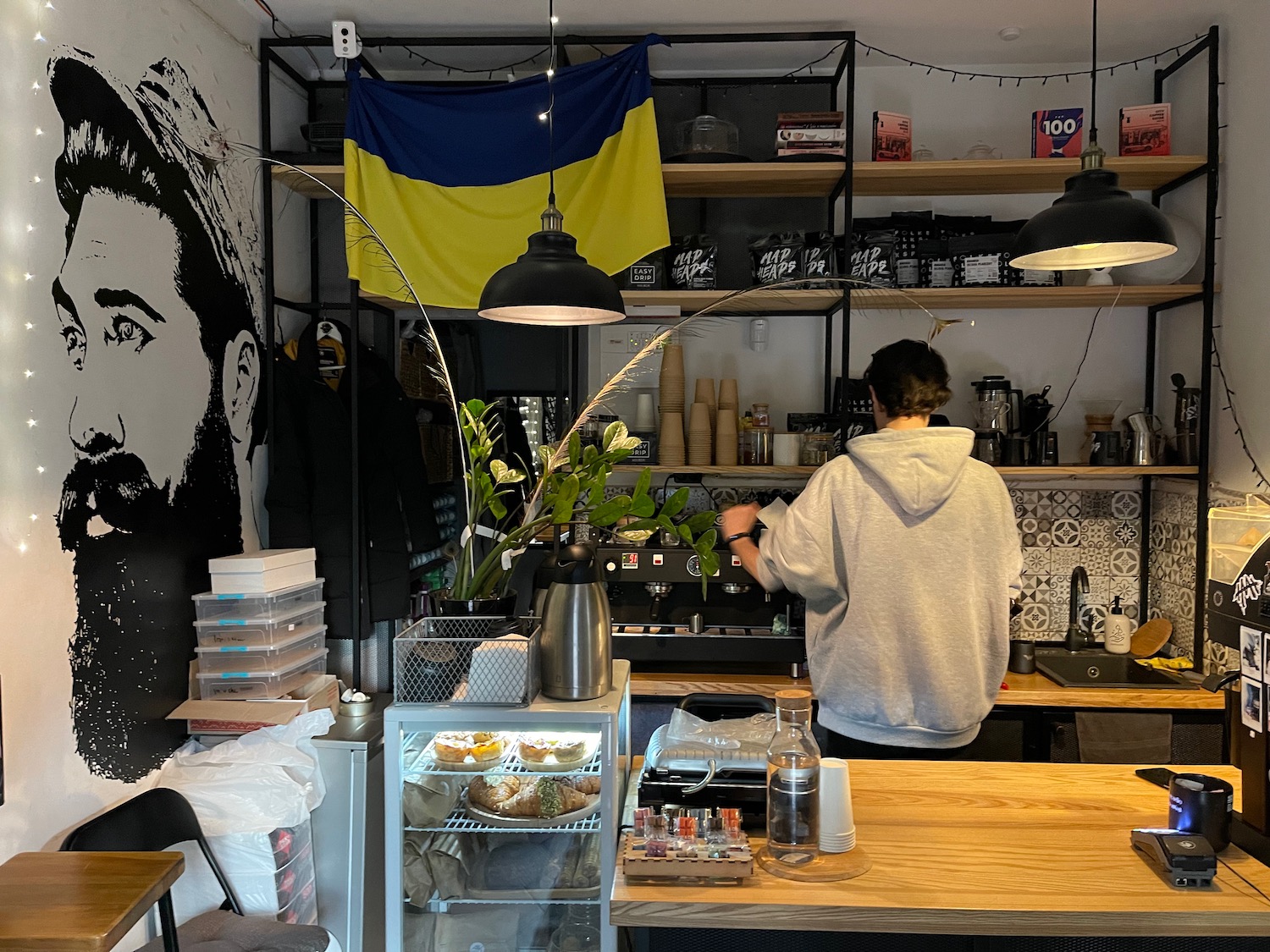 a person standing behind a counter in a coffee shop