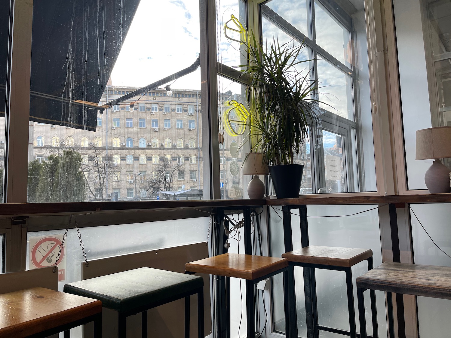 a window with a plant and stools